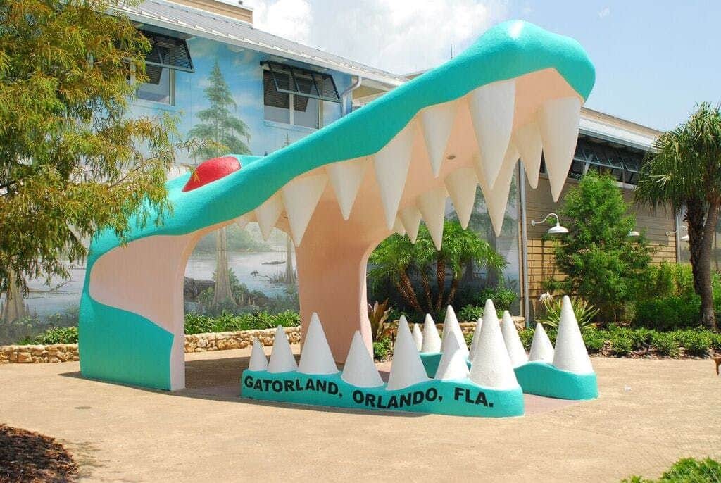 Gatorland Orlando: Skip The Line Ticket Large alligator mouth entrance with sharp teeth at Gatorland, Orlando, FL, with a mural and plants in the background.